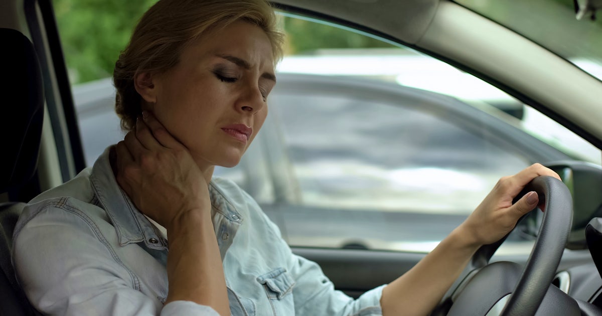 Tired female driver sitting in auto and massaging 