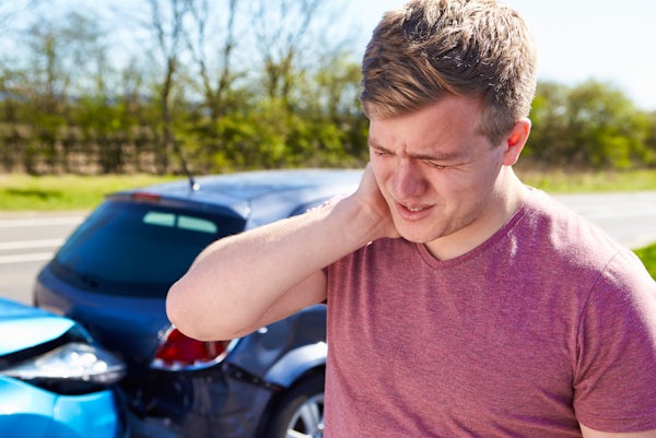 person holds neck in pain after auto collision